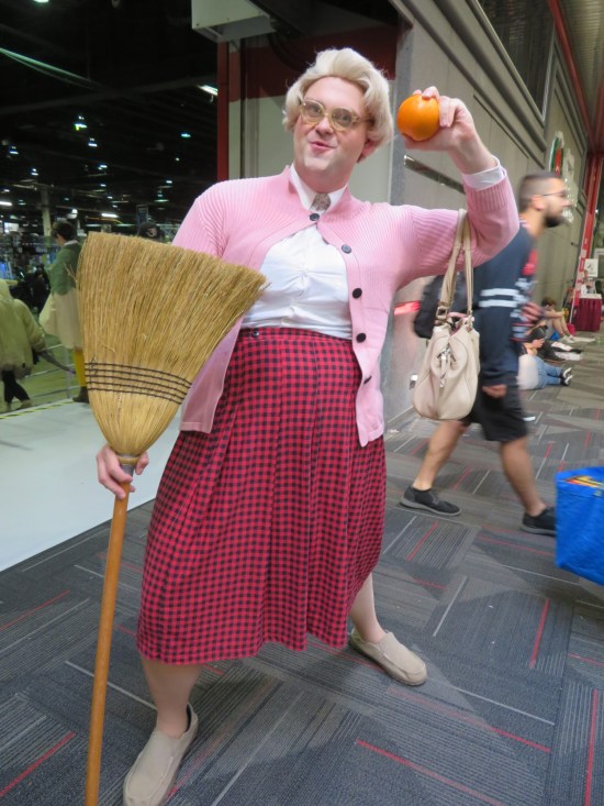 Tall Mrs. Doubtfire cosplayer preparing to hurl an orange.