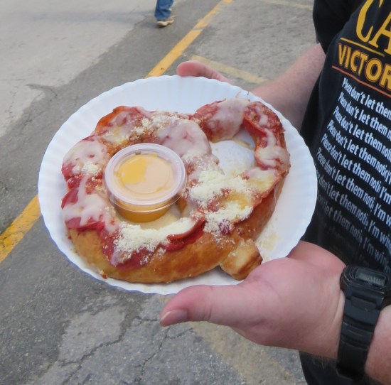 Pepperoni Pizza Pretzel served with cheese sauce.