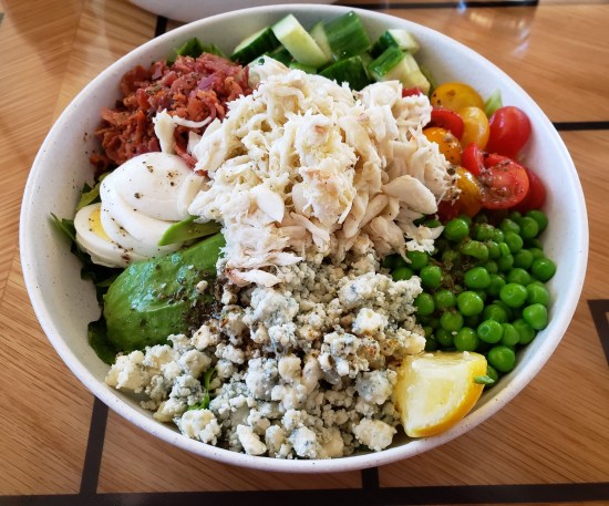 Saltwater Crab Cobb Salad with Bleu cheese crumbles, avocado, boiled eggs, real bacon bits, cherry tomatoes, cucumbers and peas.