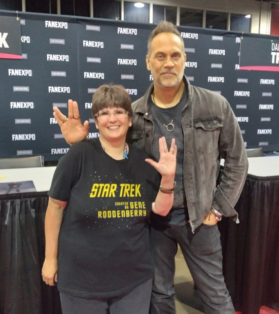 Anne standing next to Todd Stashwick, who's a head taller than her. Both are doing Vulcan hand-signs.