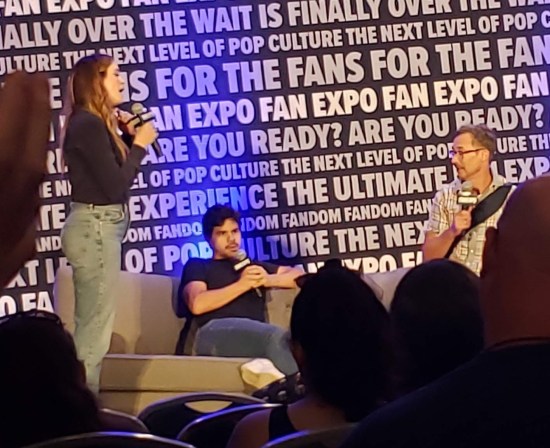 Danielle Panabaker, Carlos Valdes and Tom Cavanaugh on stage with mics and a couch.