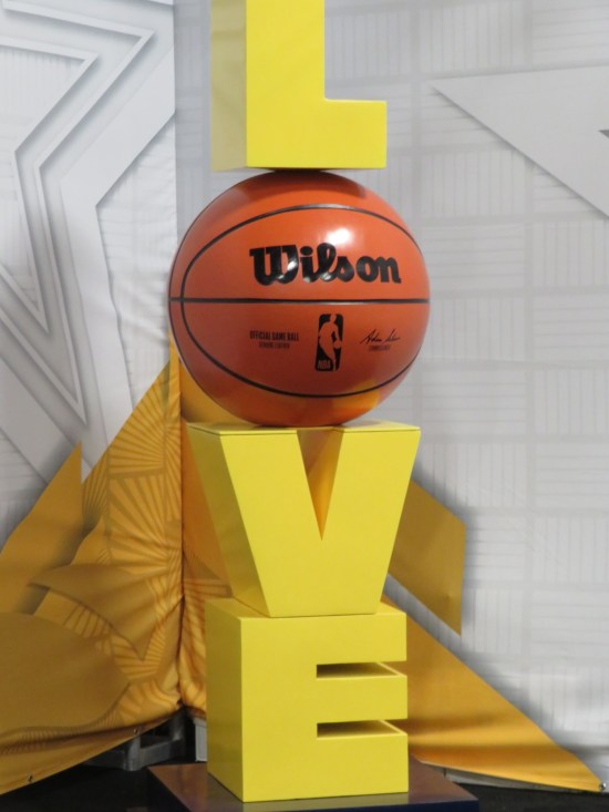 Sculpture: big yellow letters L, V, and E stacked vertically; between them, a basketball stands in for the letter O.