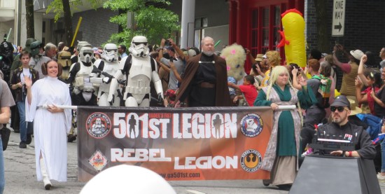 Star Wars cosplayers carrying a 501st Legion banner. Princess Leia, Count Dooku, several Stormtroopers.