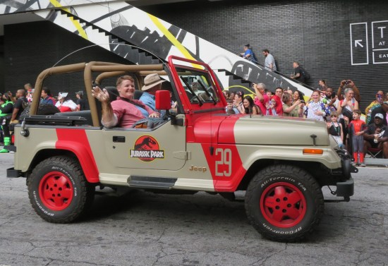Alan Grant and Ellie Sattler cosplayers in a Jurassic Park Jeep