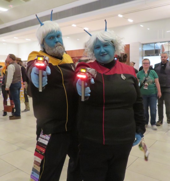 cosplay: one male and one female Andorian, both in Trek uniforms and pointing phasers at the camera.