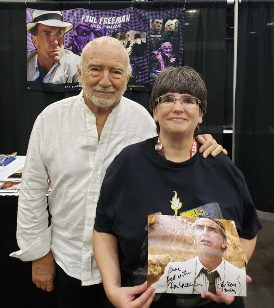 Anne and Paul Freeman, with his table banner in the background.
