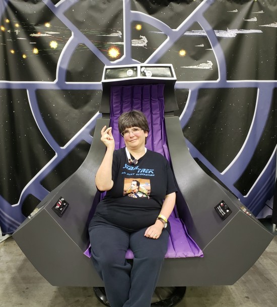 Anne sitting in a replica Palpatine throne, pretending to snap her fingers.