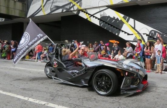 A gray Pontiac Slingshot, a sharp-angled roofless two-seat sports car.