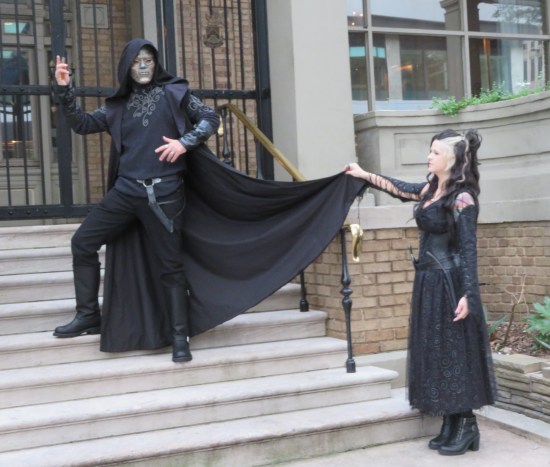 cosplay: Bellatrix Lestrange and Death-Eater, outdoors on concrete steps.