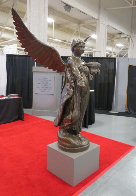 A 7-foot-tall angel statue with wings spread, standing on a concrete cube.