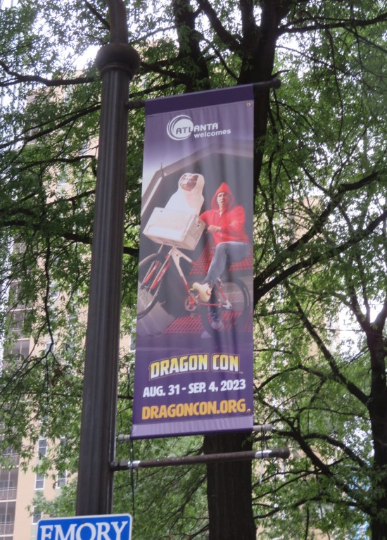 Dragon Con banner with Elliott cosplayer from "E.T." on it.