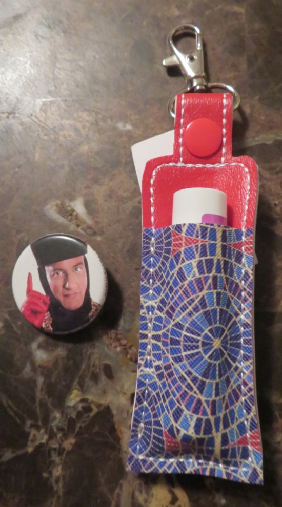 A Star Trek 'Q' button and a lip balm holder made in the Cult of Marriott Marquis Carpet pattern.