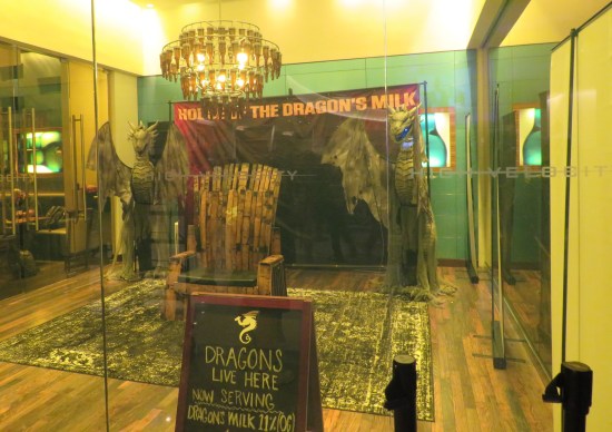 A stand called Dragon's Milk, in a room fenced off by yellow glass.