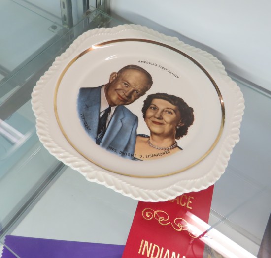 A collectible plate with the Eisenhowers' faces painted on it. It was given a red second-place ribbon.