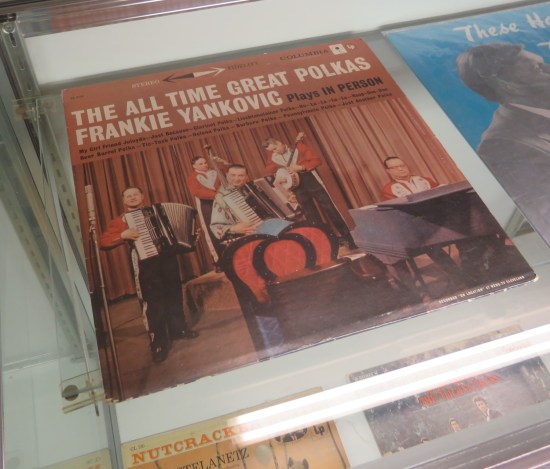 Old album: "The All Time Great Polkas: Frankie Yankovic Plays in Person". The band is photographed in ugly shades of brownish-red.