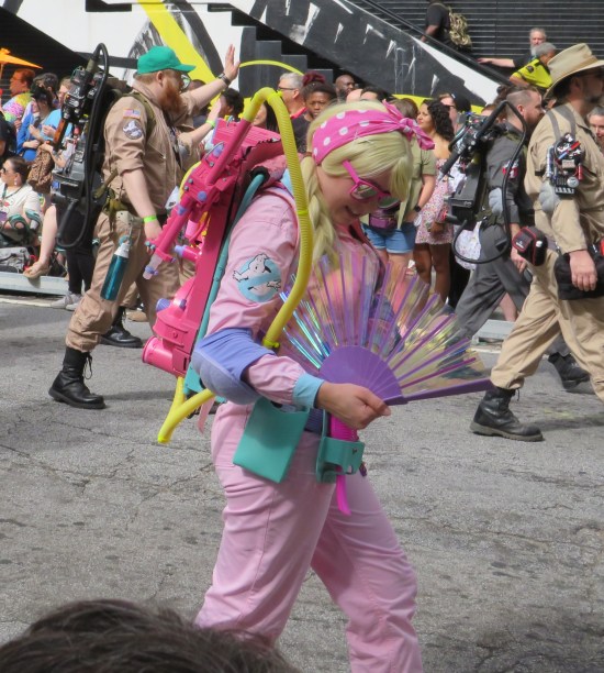 Ghostbuster Barbie costume with pink proton pack and a large pink fan.