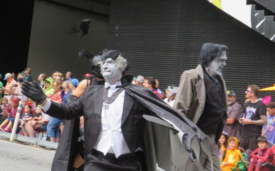 cosplay: Herman Munster walks away while Al Lewis' Grandpa holds up his arms and looks upon the crowd for approval.