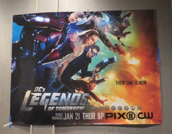Large poster for DC's "Legends of Tomorrow" with the entire season-1 cast flying left to right.