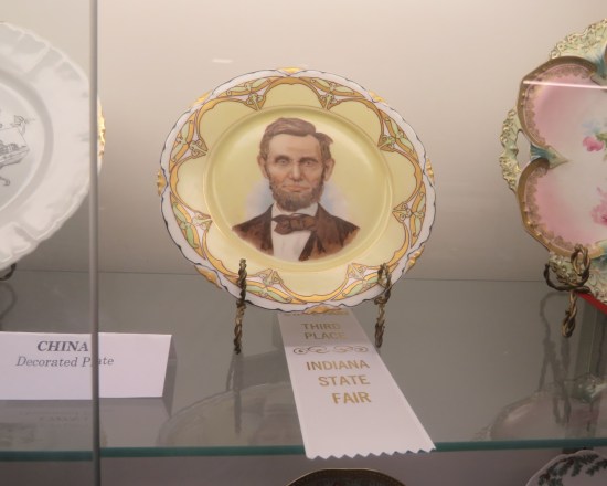 An old plate with Lincoln's face painted on it. It was awarded a white Third Place ribbon.