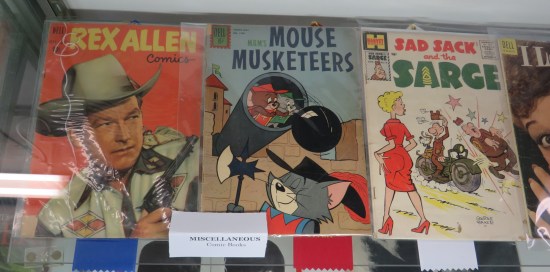 Three old comics in a vitrine.