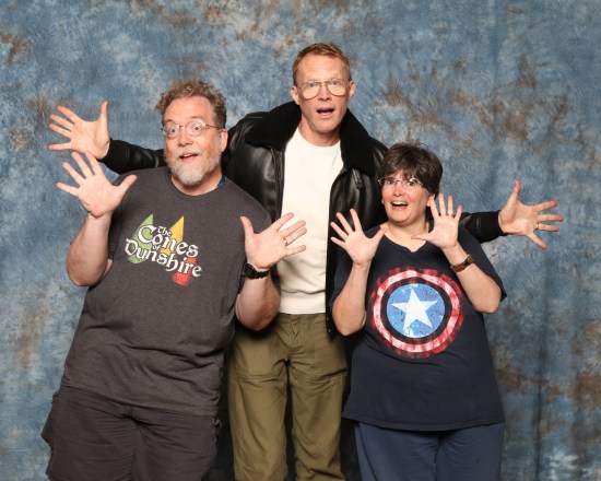 Us doing jazz hands with the tall and rather game Paul Bettany, who's wearing a bomber jacket and glasses.