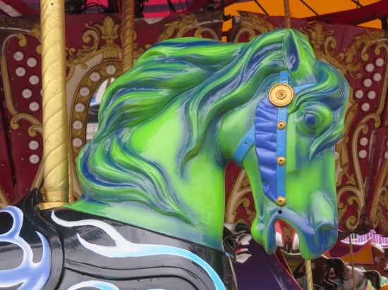 The head of a carousel house painted alarmingly bright green.