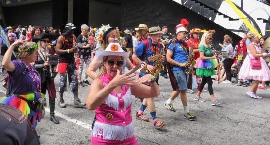 Barbie in Western getup in front of a marching band who wear whatever they feel like because they aren't a martial regiment.