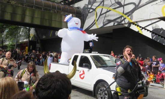 An inflatable Stay Puft Man, smaller than the one in the film, riding in the back of a pickup truck with a Ghostbusters symbol on the door.
