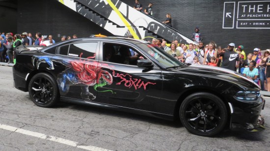 A Mustang or some other black car with the character and logo of Toxin painted on the side.