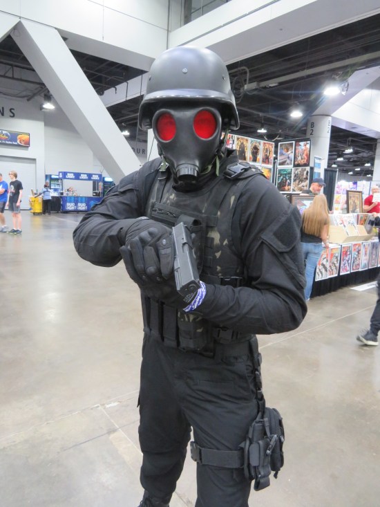 cosplay: Umbrella Corporation soldier, rifle pointed at the camera.
