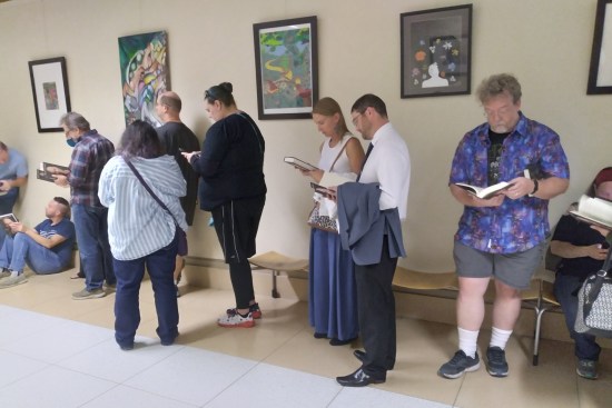Me andseveral other fans standing in line, holding or reading our new books.