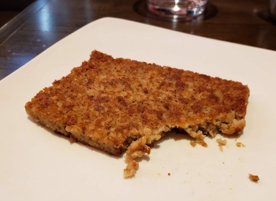 A square goetta patty with a corner trimmed off because I forgot to take a pic before taking my first bite.