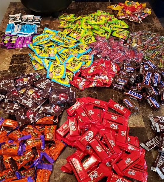 Our kitchen table covered with over 300 pieces of candy in ten different piles. Possibly as many as 400. I lost count.