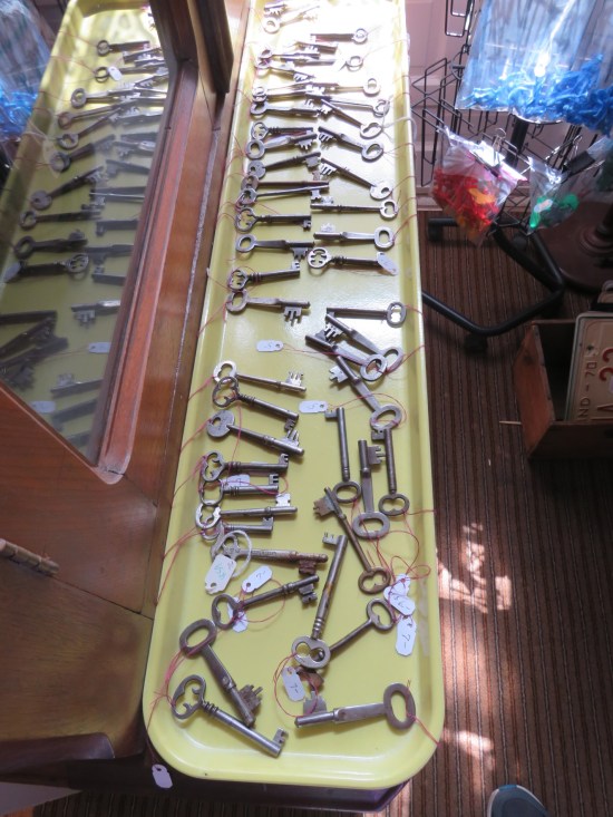 Dozens of keys on a long-rectangular shelf.