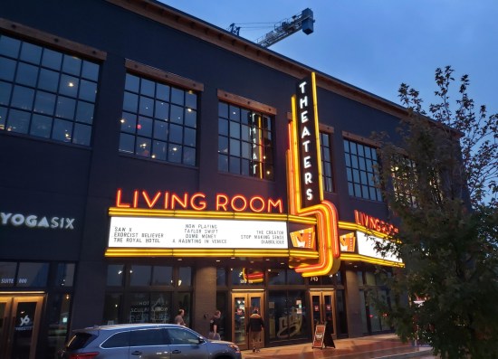 Living Room Theaters front doors and marquee with several films listed, including Taylor Swift's concert film "Eras", now the #1 film in America.