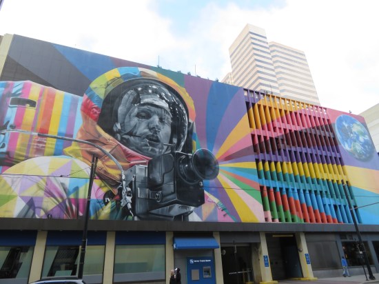 A big Neil Armstrong mural on the side of a parking garage. He's in his astronaut suit and holding a camera shooting rainbows out of the lens.