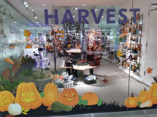 Museum gift shop full of orange objects, pumpkin shapes, , and the word "HARVEST" hanging from the ceiling.
