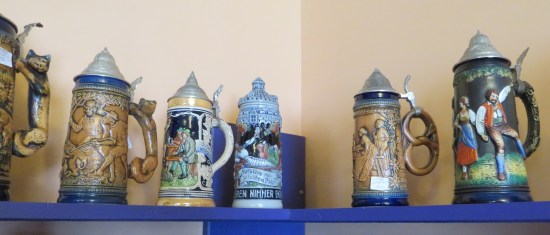 A high shelf with beer steins in several intricate designs.