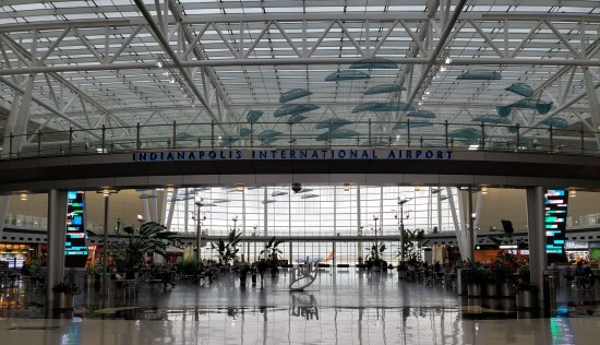 Indianapolis International Airport's concourse food court, with a shiny floor and some modern ceiling mobiles that look like leaf-shaped UFOs.