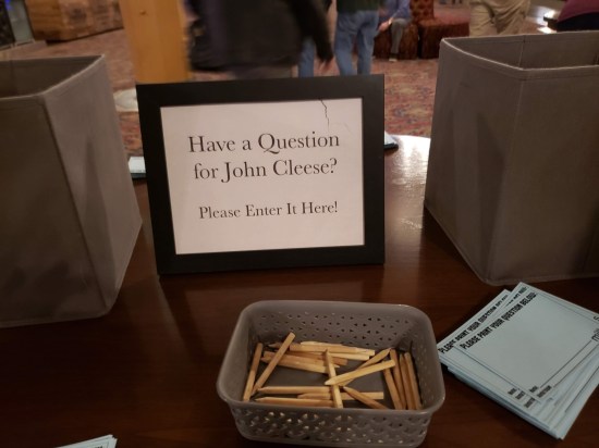 Table holding two empty card boxes, a sign that says 
