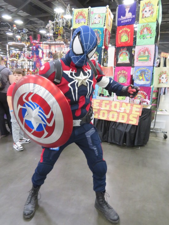 Cosplay mashup of Spider-Man and Captain America. His America-colored shield has a big black spider on it.