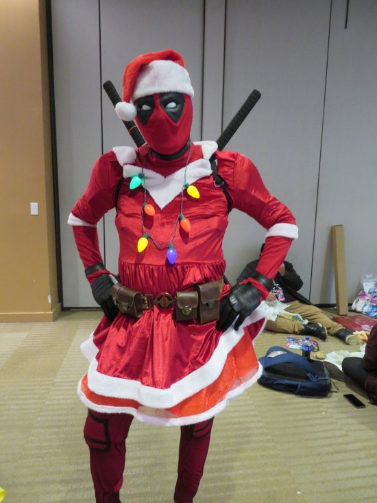 Deadpool cosplayer with added Santa hat, Christmas lights, white fur trim and skirt.