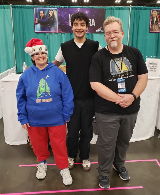 Us posing politely with Evan Evagora in front of his booth, no jazz hands.