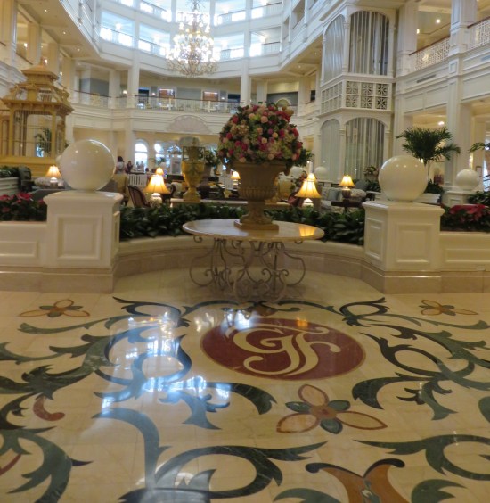 Calligraphic letters GF in a red circle drawn on the floor. Next to them is a table holding a large bouquet of dozens of flowers.