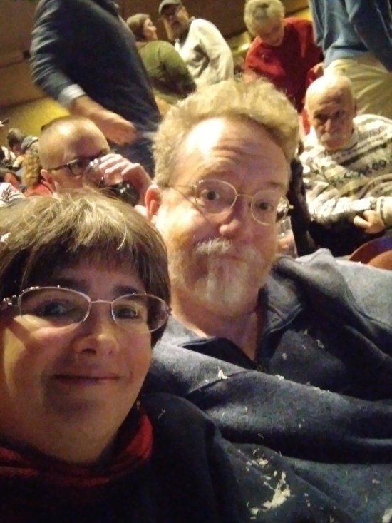 Selfie of me and Anne during intermission, still with bits of fake snow stuck to us. Behind us are patrons who missed out.