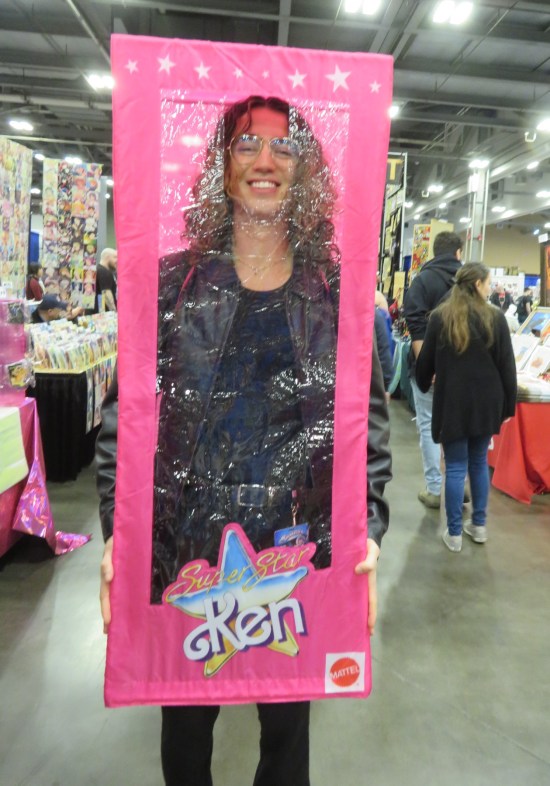 Guy wearing a human-sized Barbie-style "Super Star Ken' box.