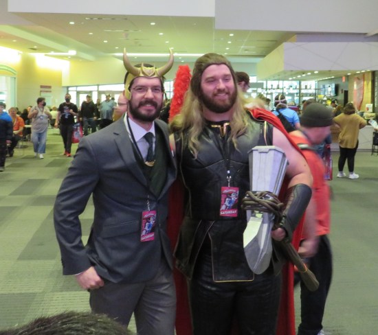 Loki and Thor cosplayers. Loki is in a business suit.