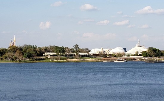 Grainy zoom-lens shot of Disney's Magic Kingdom across the lagoon.