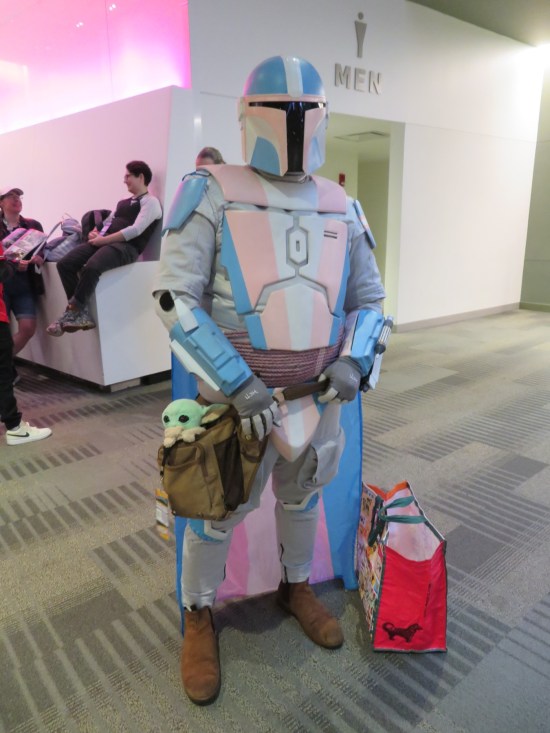 Mandalorian cosplay in light blue, pink and white.