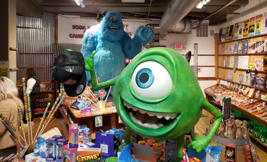 Candy store with statues of Mike Wazowski and Sully Sullivan from Pixar's "Monsters Inc." standing on two of the store's islands.